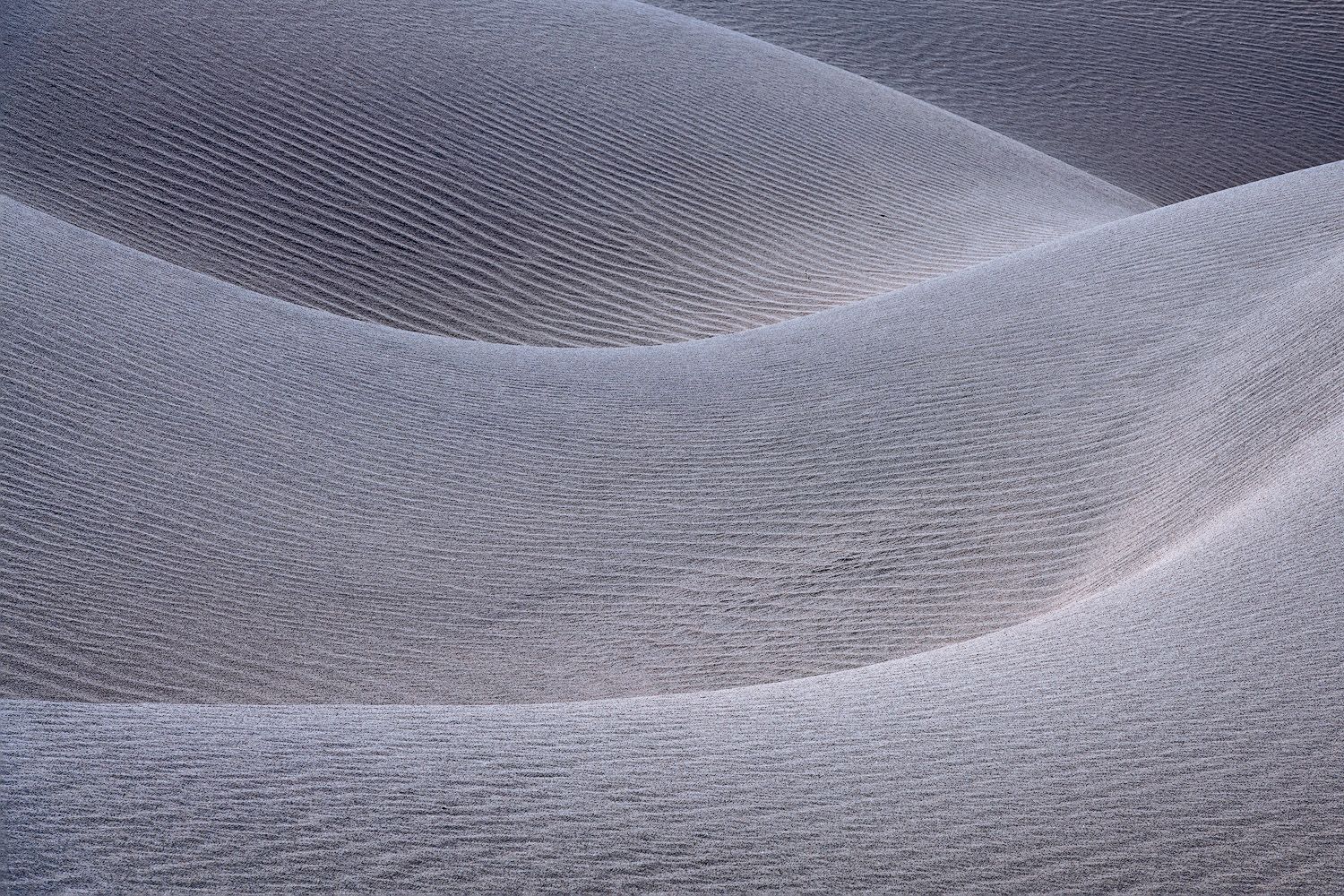 Ethereal sand dune landscape with soft ripples and curves creating a dreamy atmosphere.