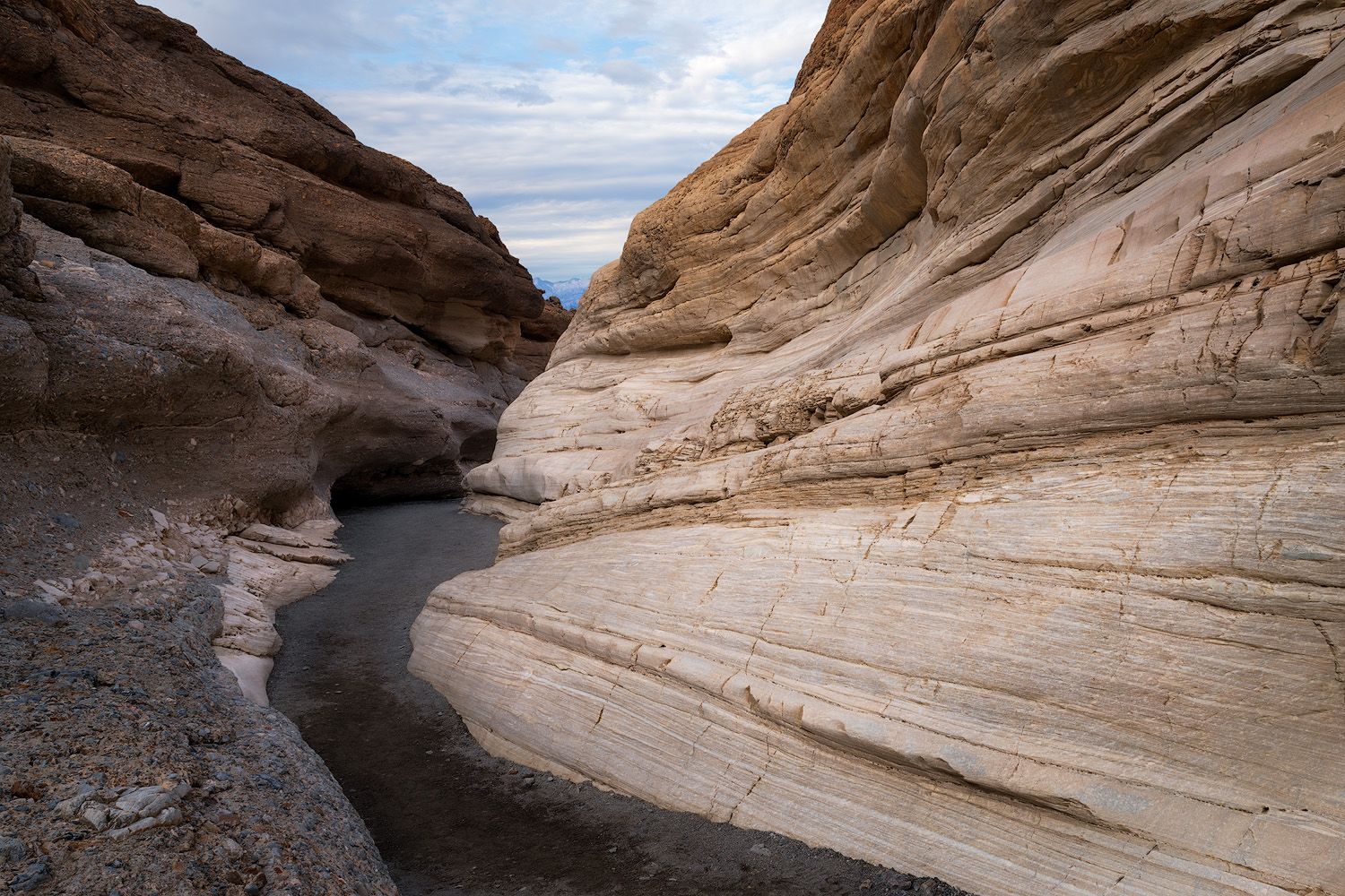 Winding canyon path cuts through layered sandstone walls in Death Valley.