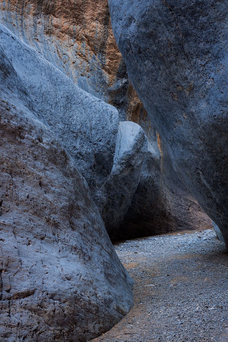 Steep canyon walls frame a narrow winding path through rocky terrain.