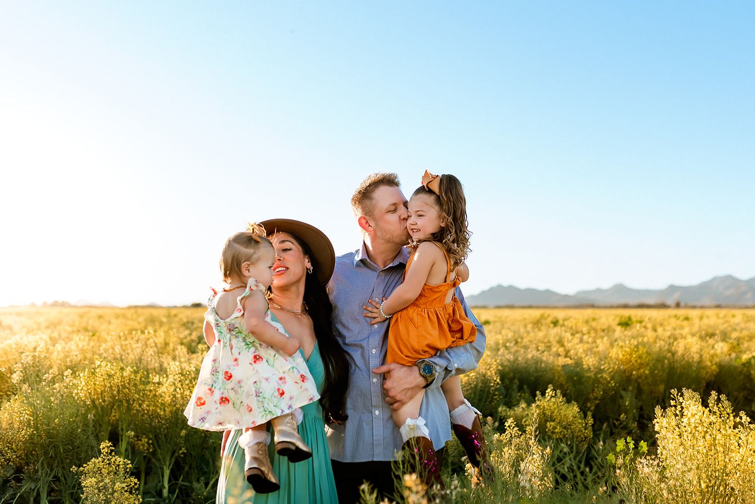 Family cuddles and embraces during a golden hour session in West Valley of Phoenix, AZ.