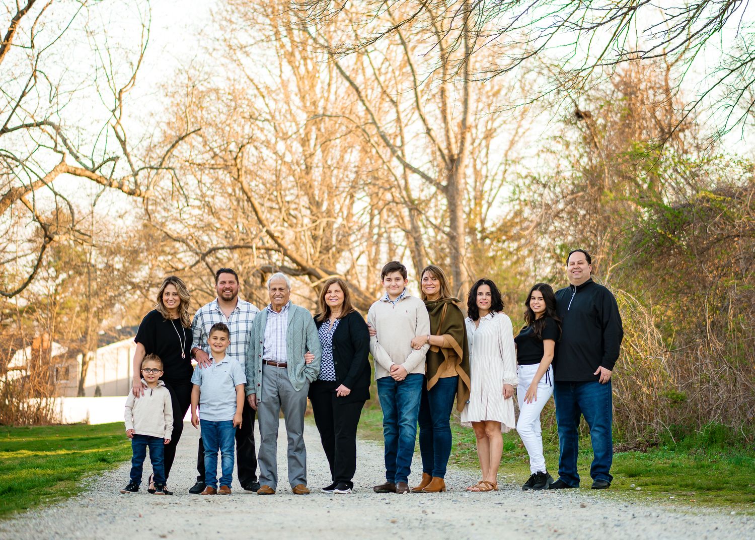 Four candid outdoor family portrait photographs taken at sunset with autumn trees in the background.