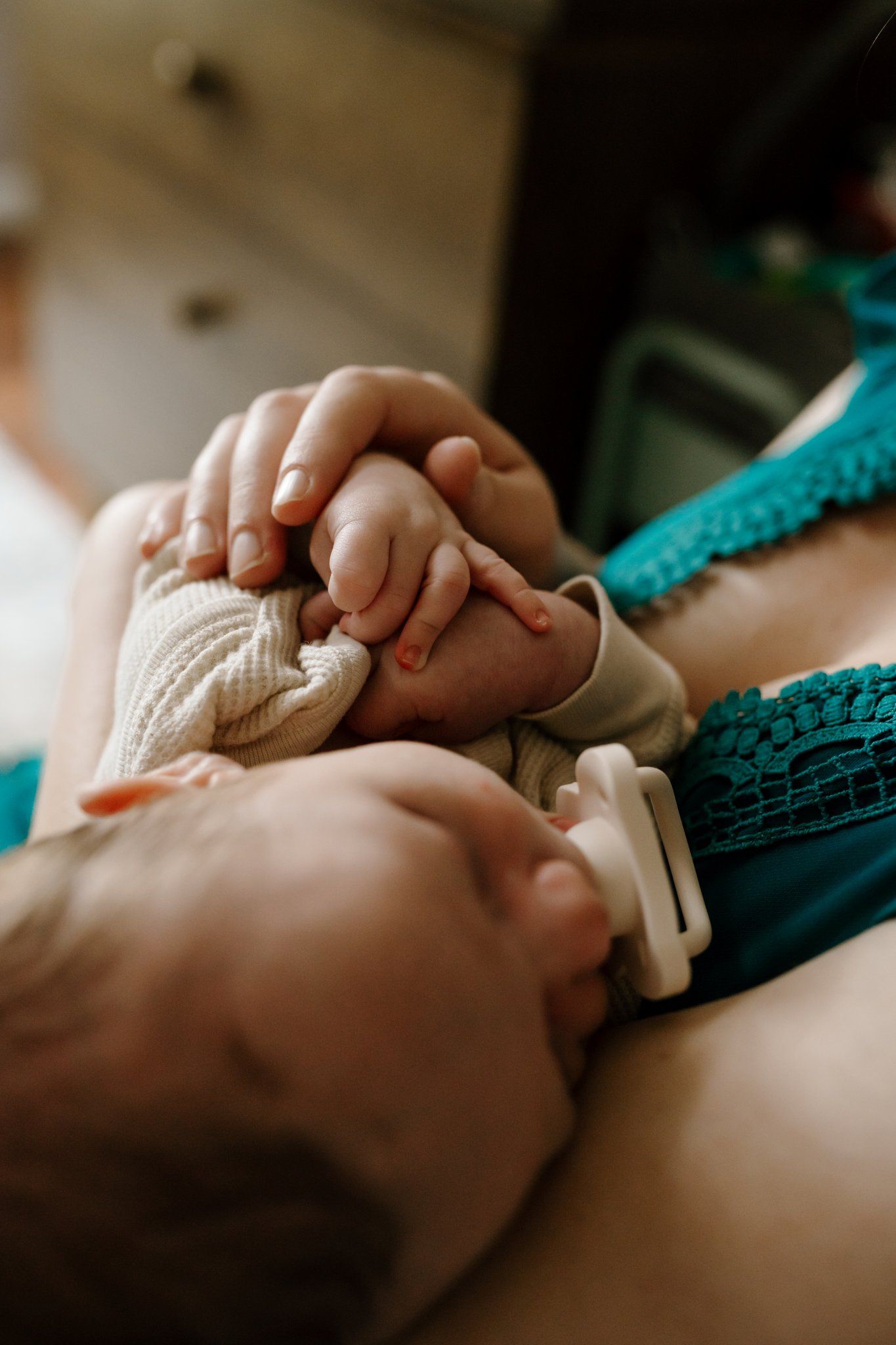 Mom plays with newborn baby's hand
