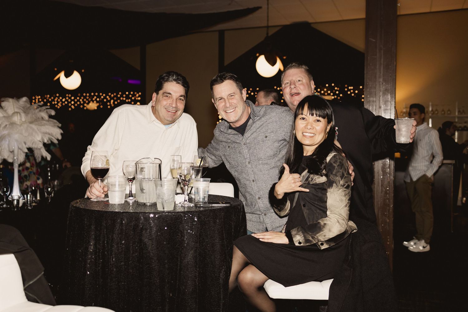 Group of friends gathered around a table at an evening social event.