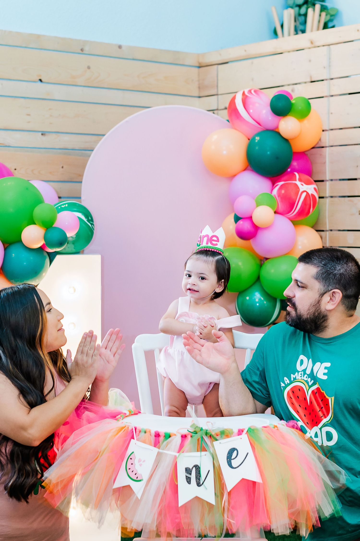 First birthday party setup with colorful balloons and heart-themed decorations.