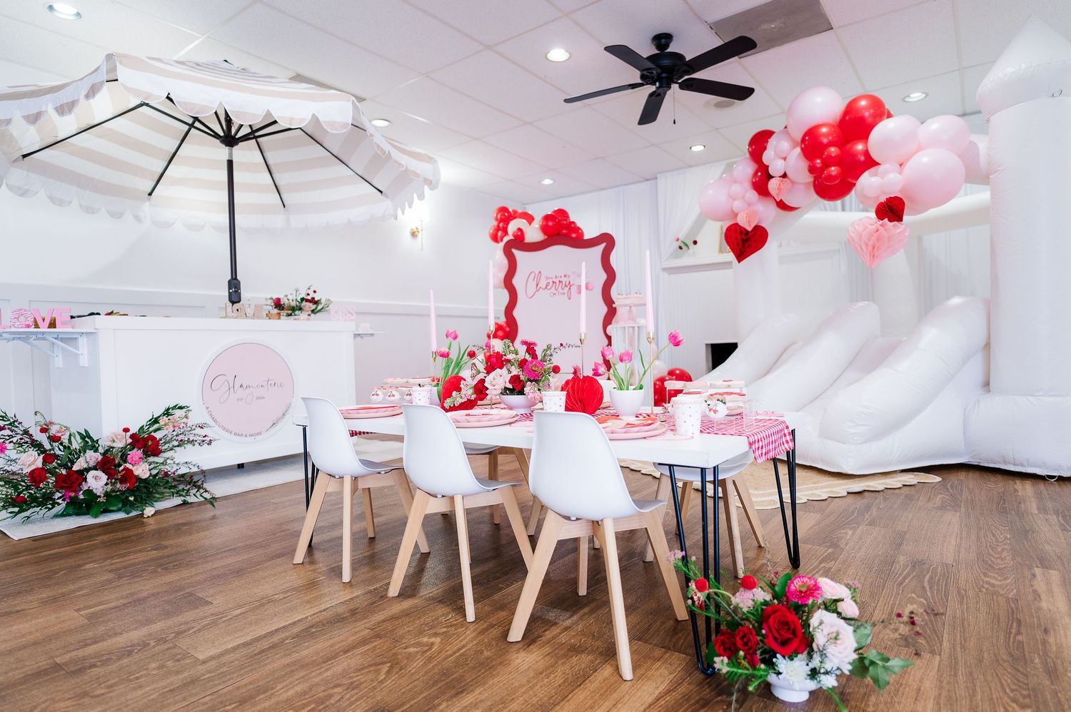 Romantic Valentine's day table setting with red and white decorations and umbrella accent.