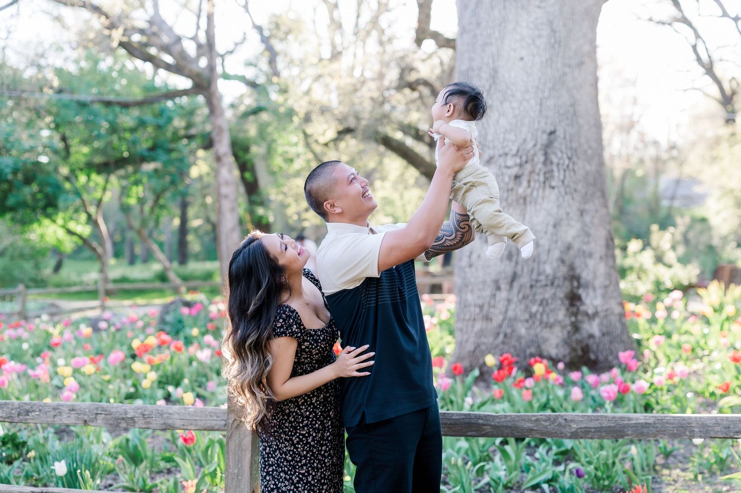 Family shares joyful moment together in blooming garden setting.