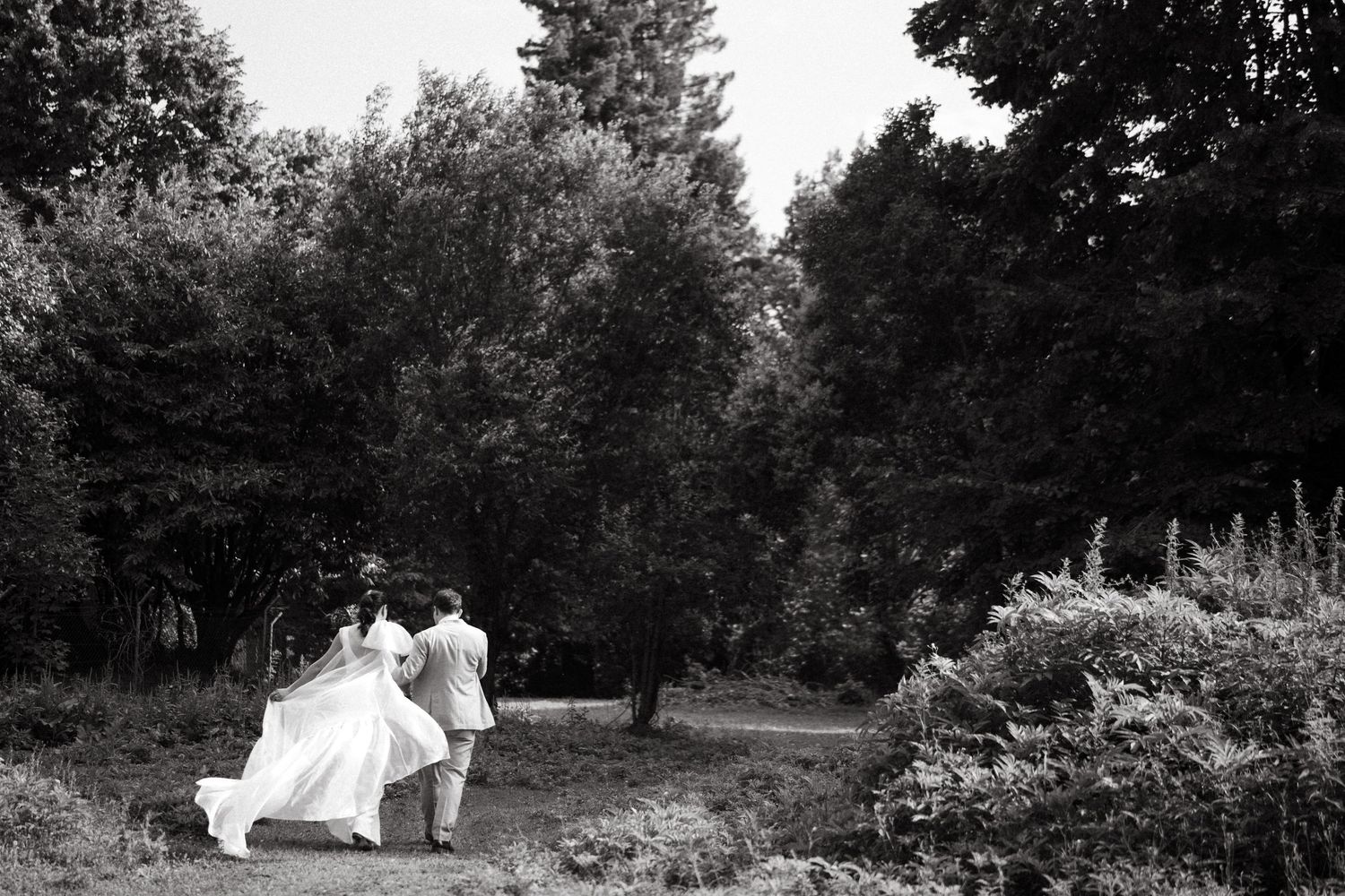 A beautiful sequence of monochrome wedding photos captured in a natural outdoor garden setting with romantic poses.