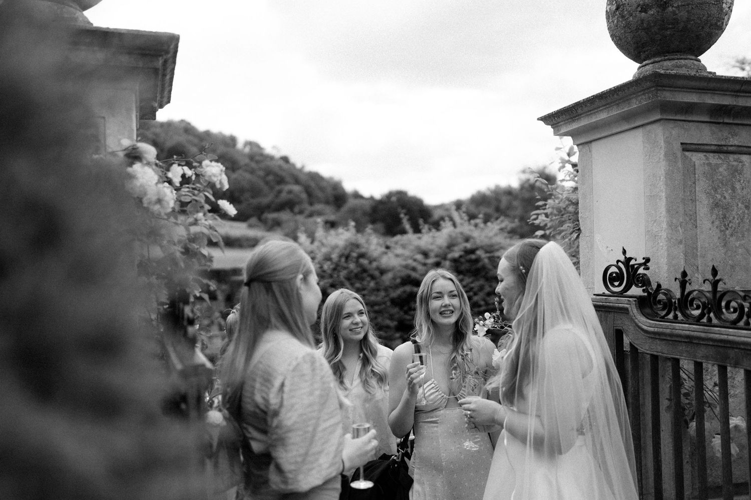 A candid black and white photograph of a joyful celebration with people gathered outdoors.