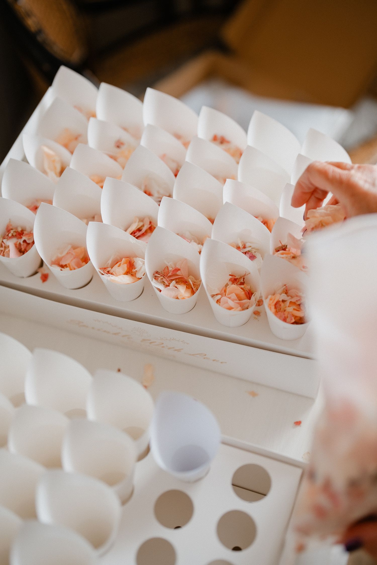 White paper cones filled with pink appetizers arranged in neat rows on a serving tray.