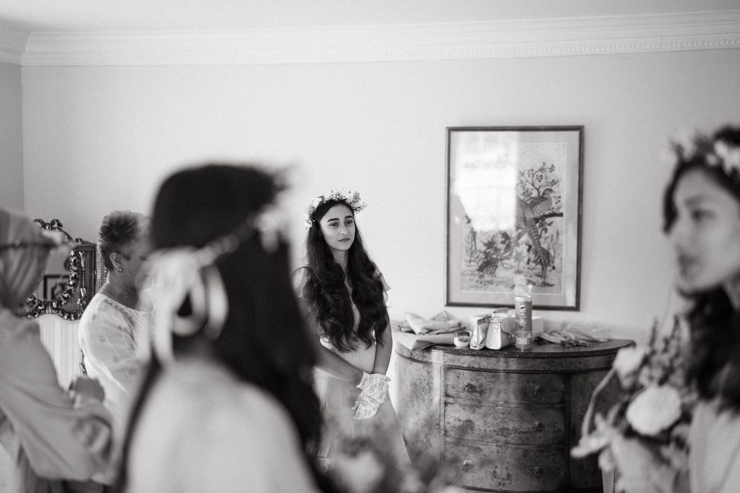 Black and white photo of wedding party gathering in a cozy interior room.