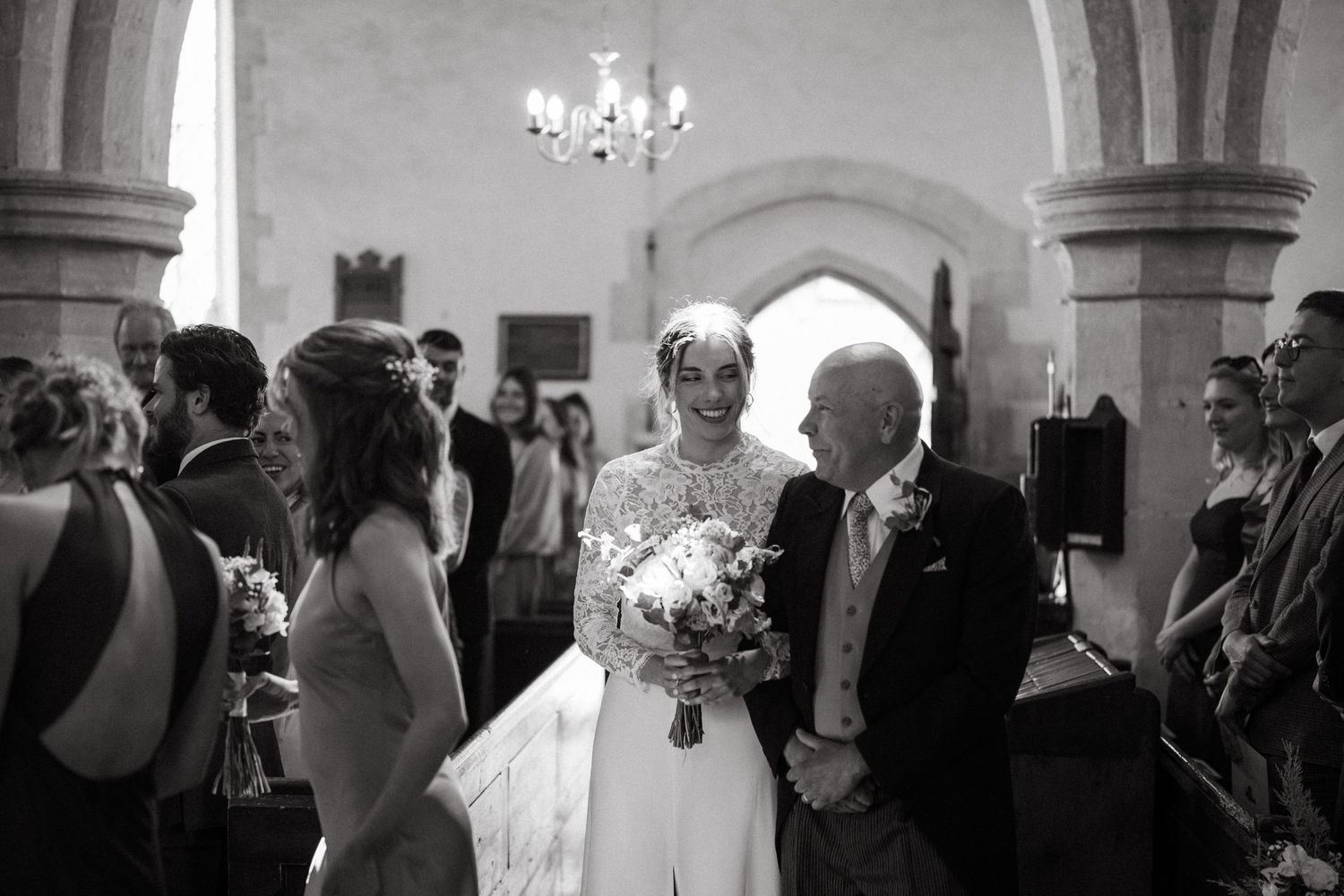 Wedding celebration in an elegant stone archway interior with guests.