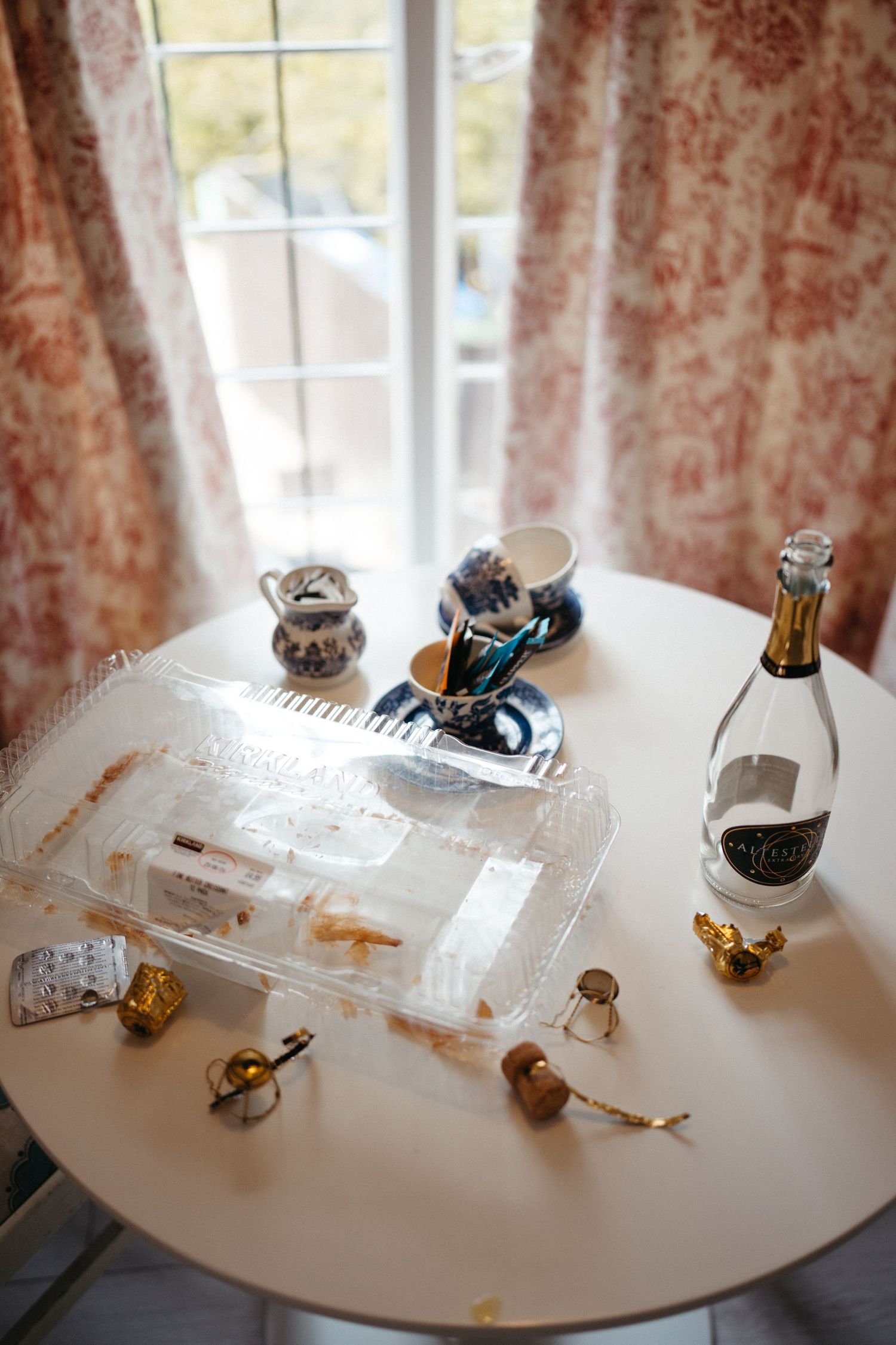 White round table with decorative items including miniature figures and a glass bottle.