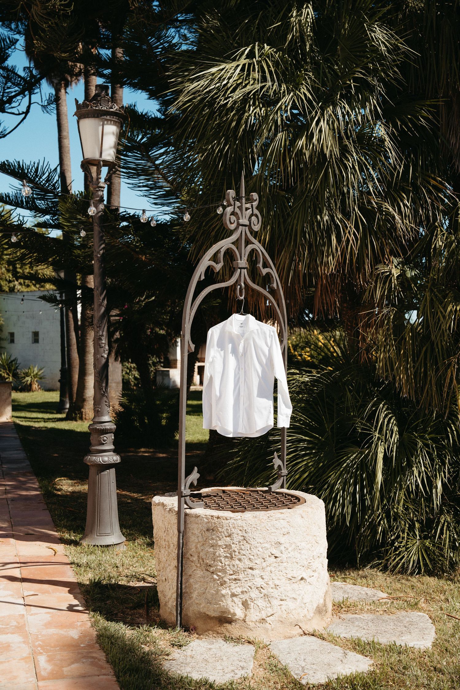 Four sequential images showing a rustic stone well with decorative metal top surrounded by palm trees and landscaping.