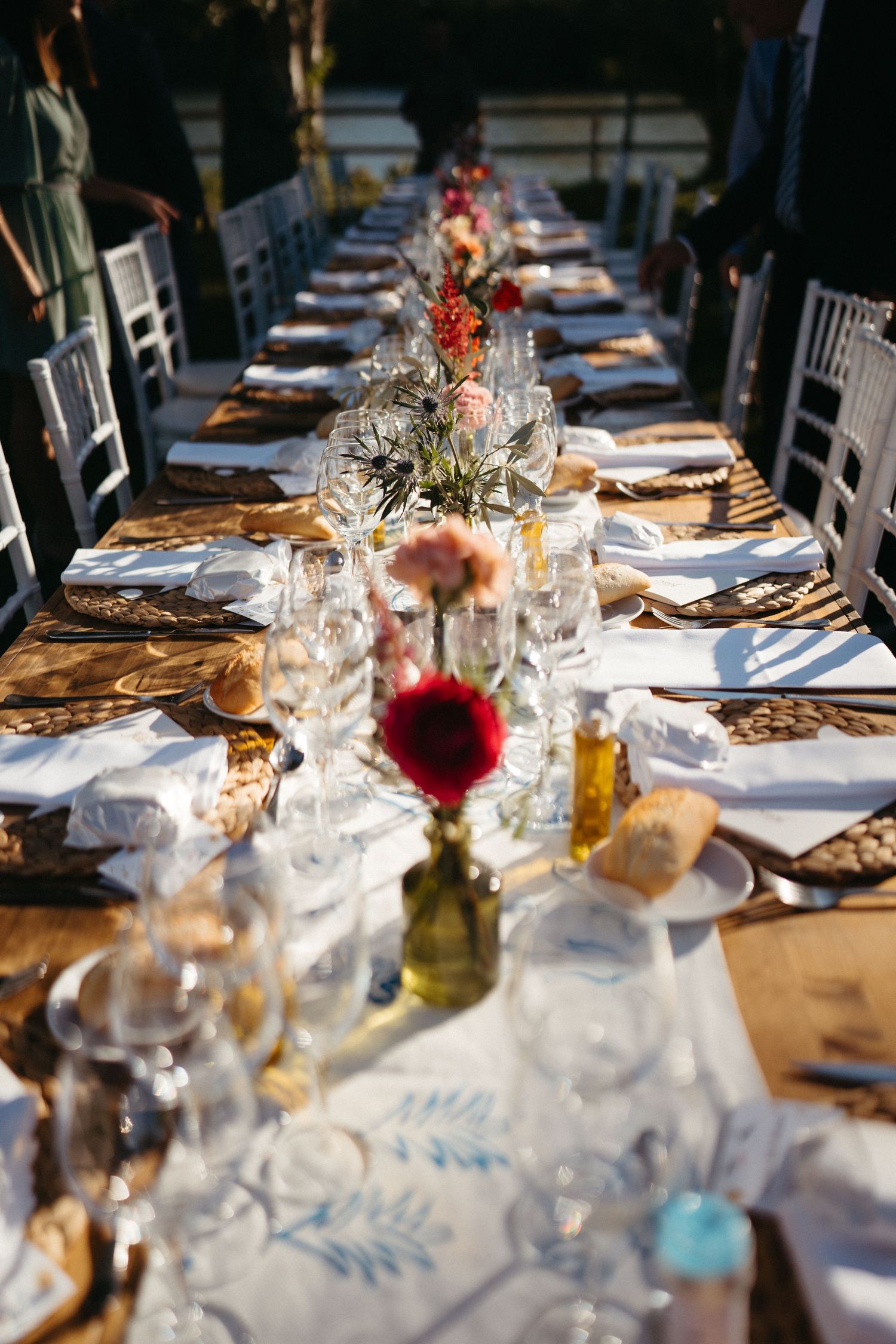 Formal dining table set for wedding reception with floral centerpieces and wine glasses.