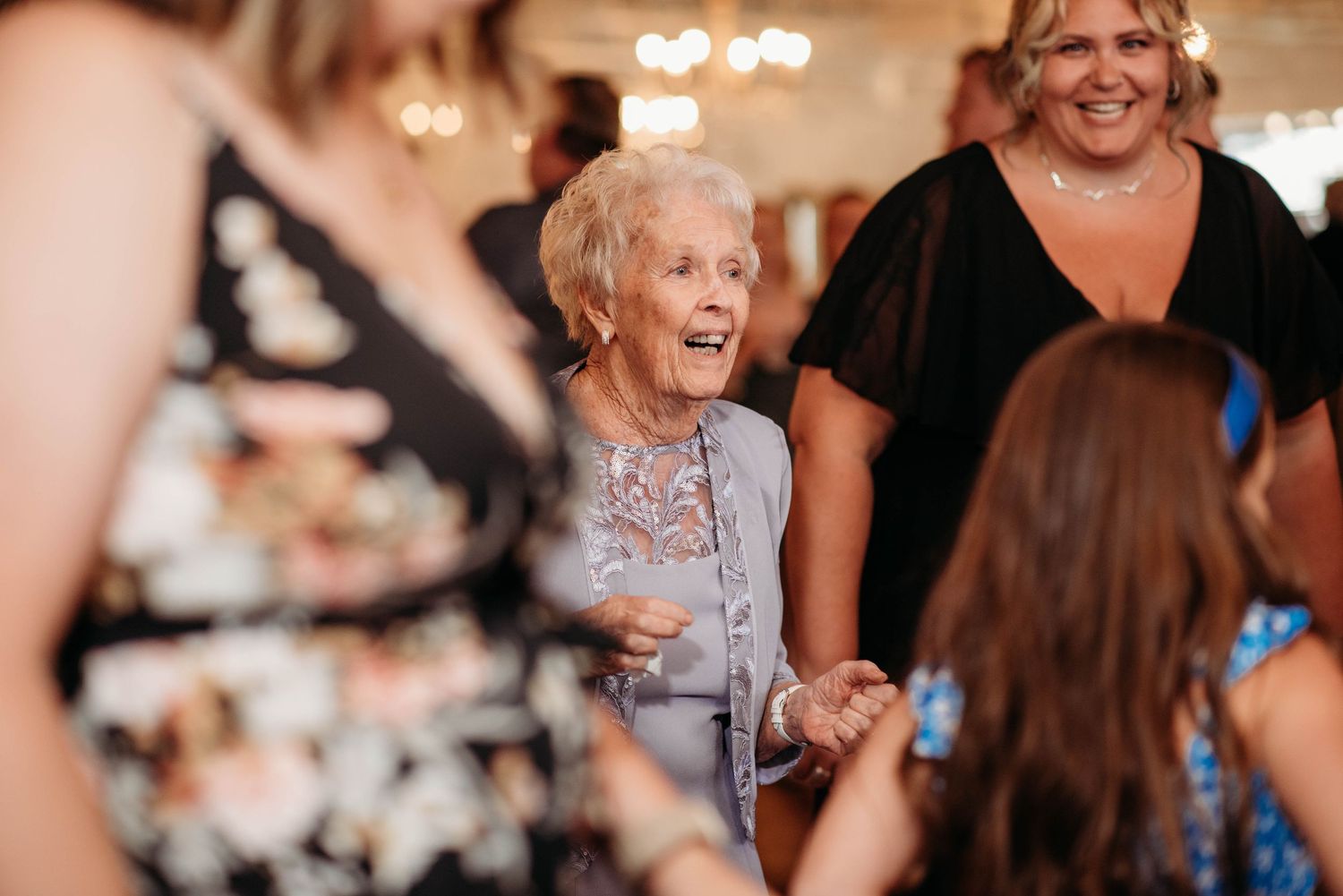 Joyful party scene showing people enjoying a celebratory moment together in warm lighting at an indoor event.