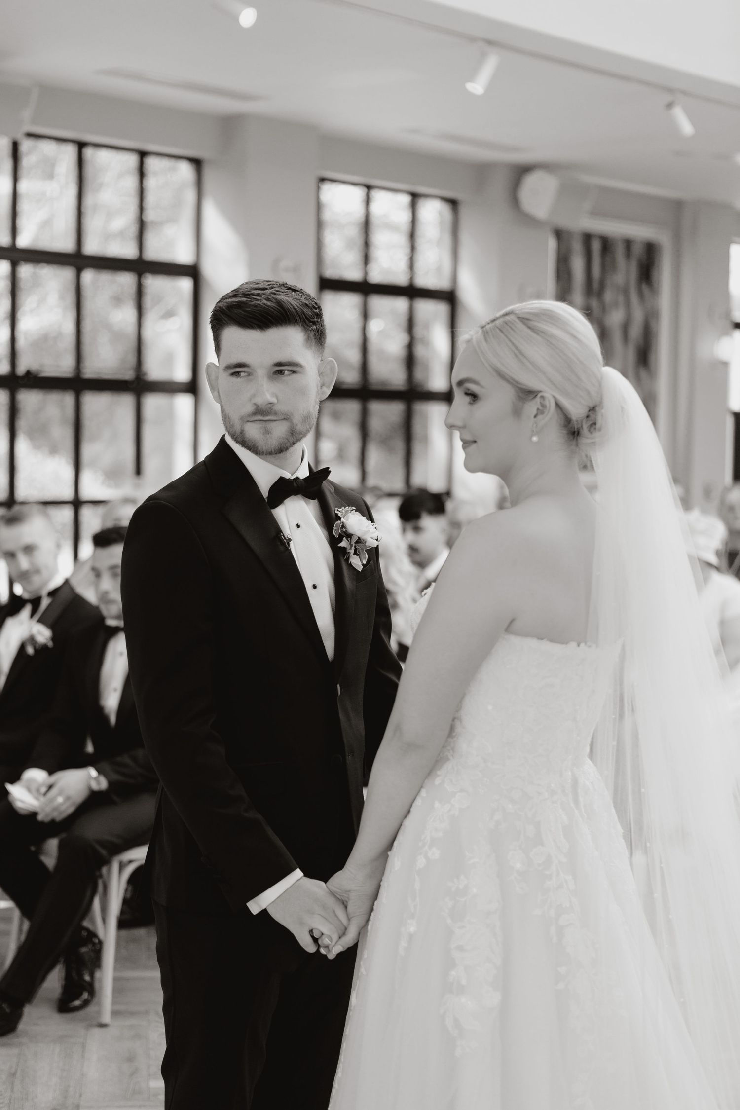 A series of three black and white first look wedding photos showing an emotional moment between bride and groom.