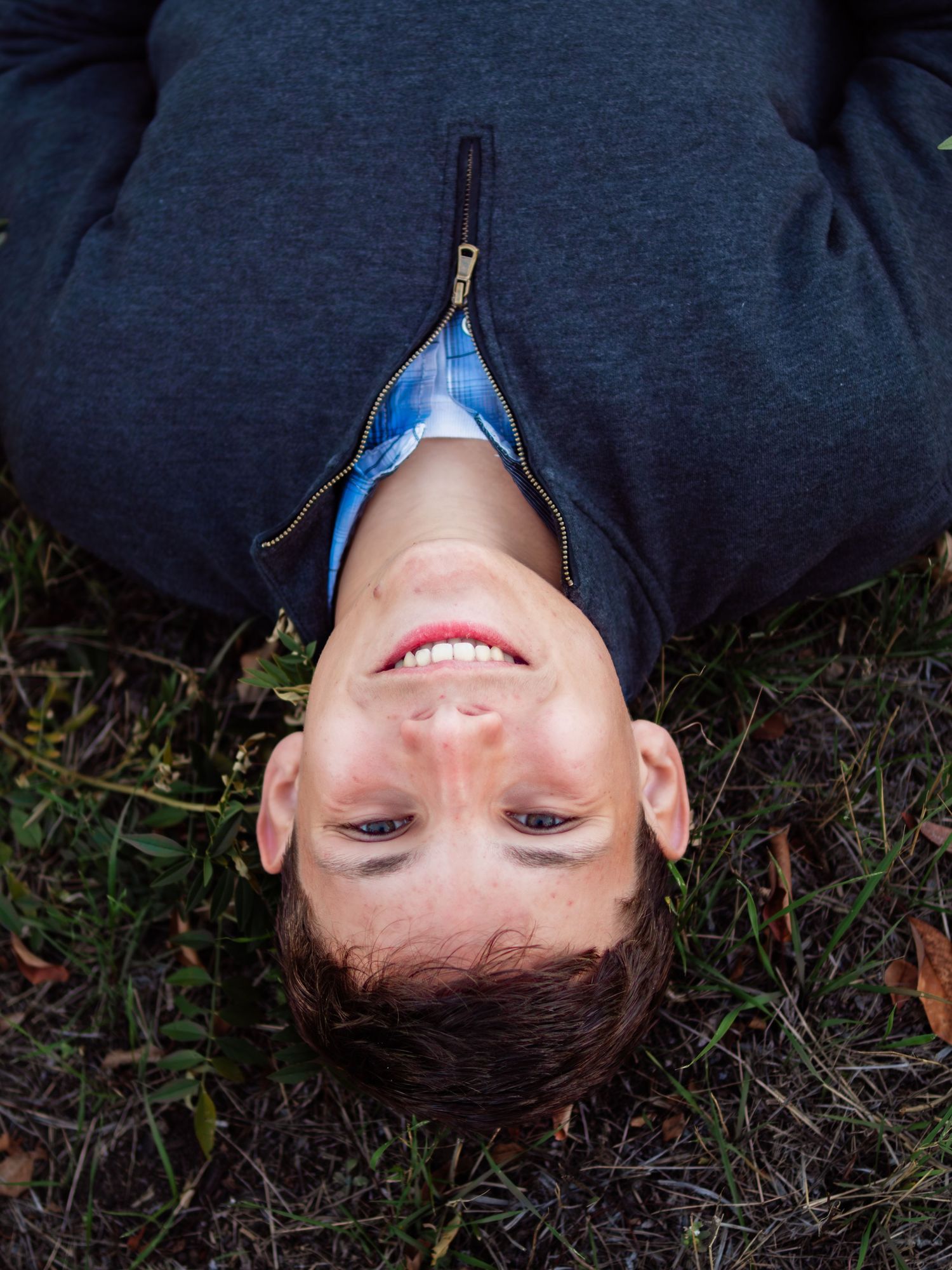 Creative upside-down portrait against grass background.