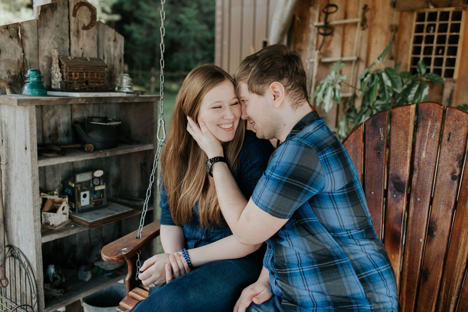 A couple embraces intimately in a rustic cabin-like setting with wooden walls and natural lighting.