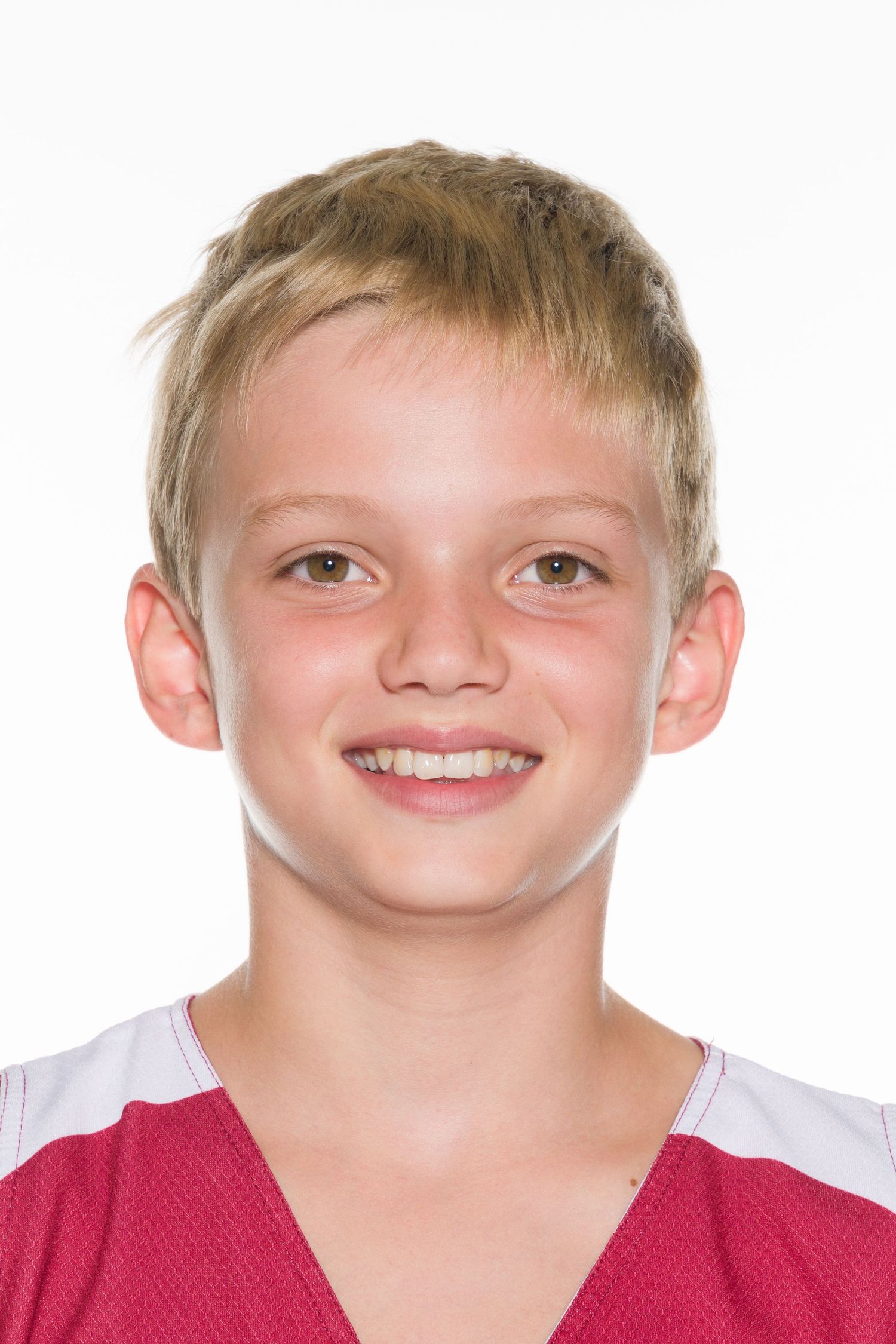 Young athlete wearing a red and white sports jersey smiles at camera while posing for team photo.