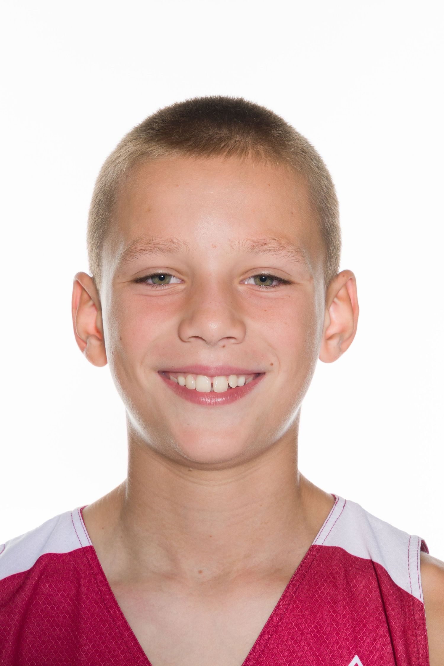 Youth athlete wearing a red and white basketball jersey with a bright smile.