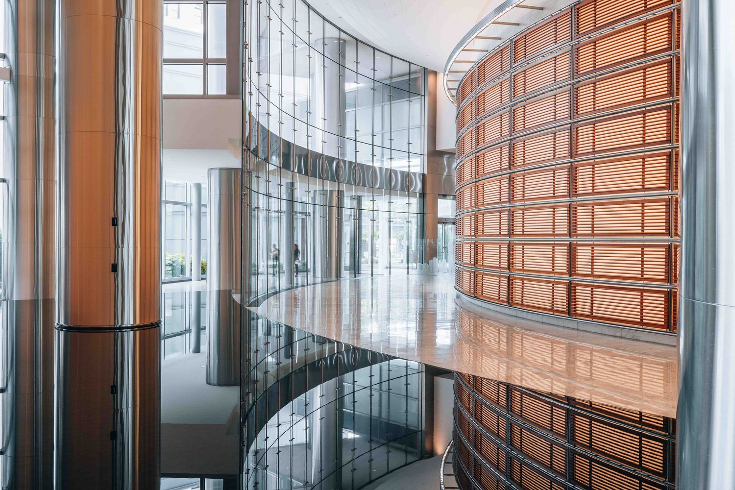 Curved glass corridor with wooden wall panels in modern office building interior.