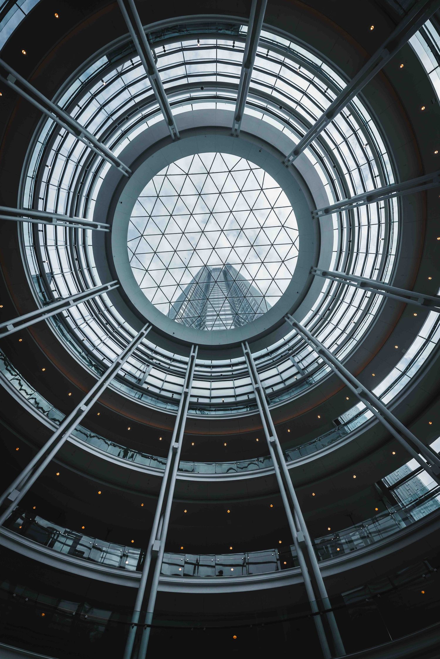 Modern architectural dome skylight with geometric triangular patterns viewed from below in dramatic perspective.
