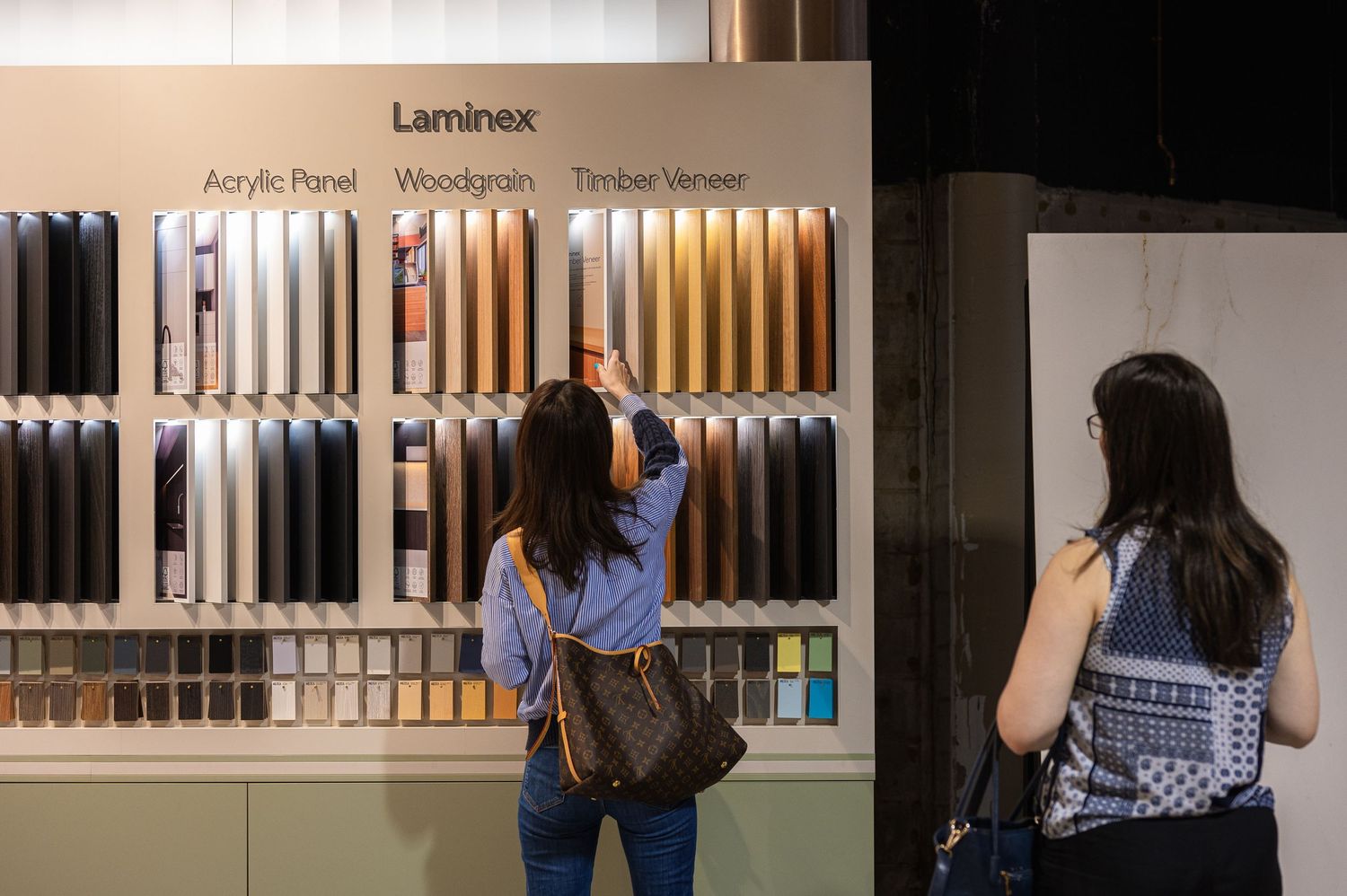 A woman picking out colours at an interior design trade show event.