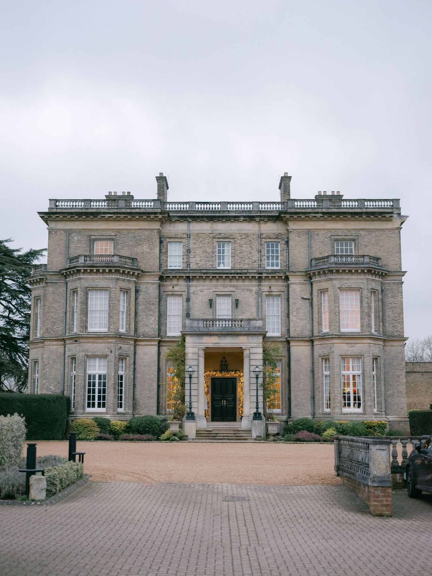Elegant stone mansion with classical architecture features a grand entrance and symmetrical facade in a traditional English style.