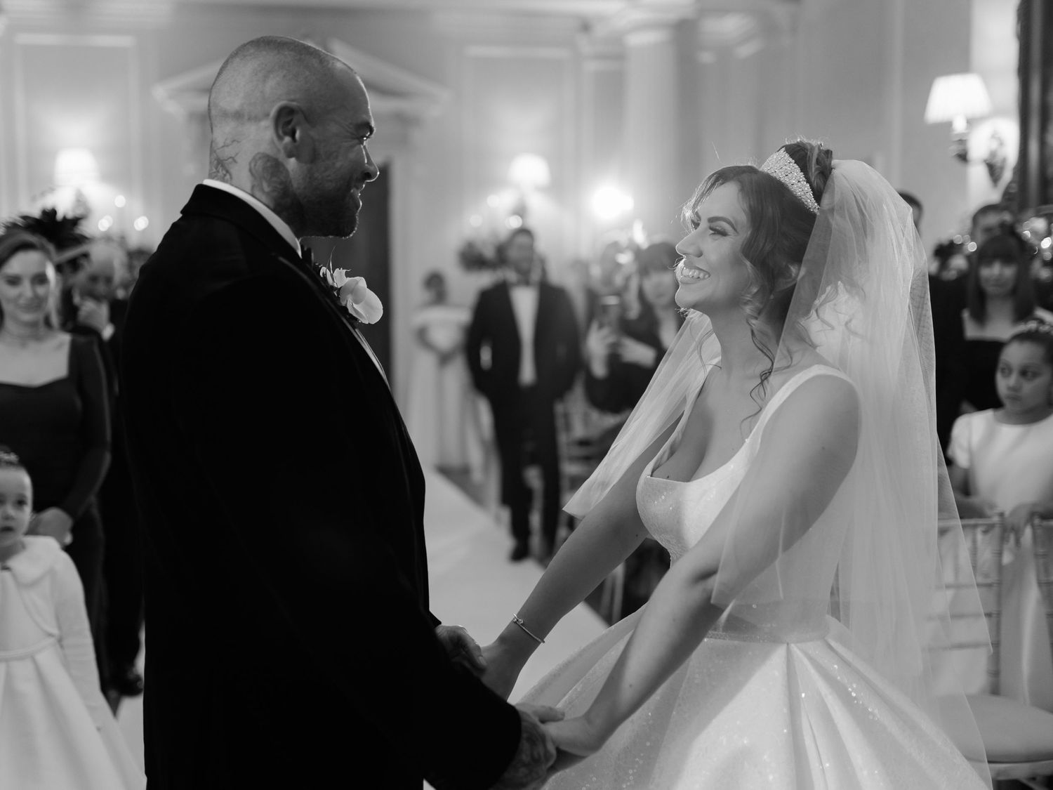 A bride and groom share a joyful moment during their first dance at an elegant ballroom wedding reception.