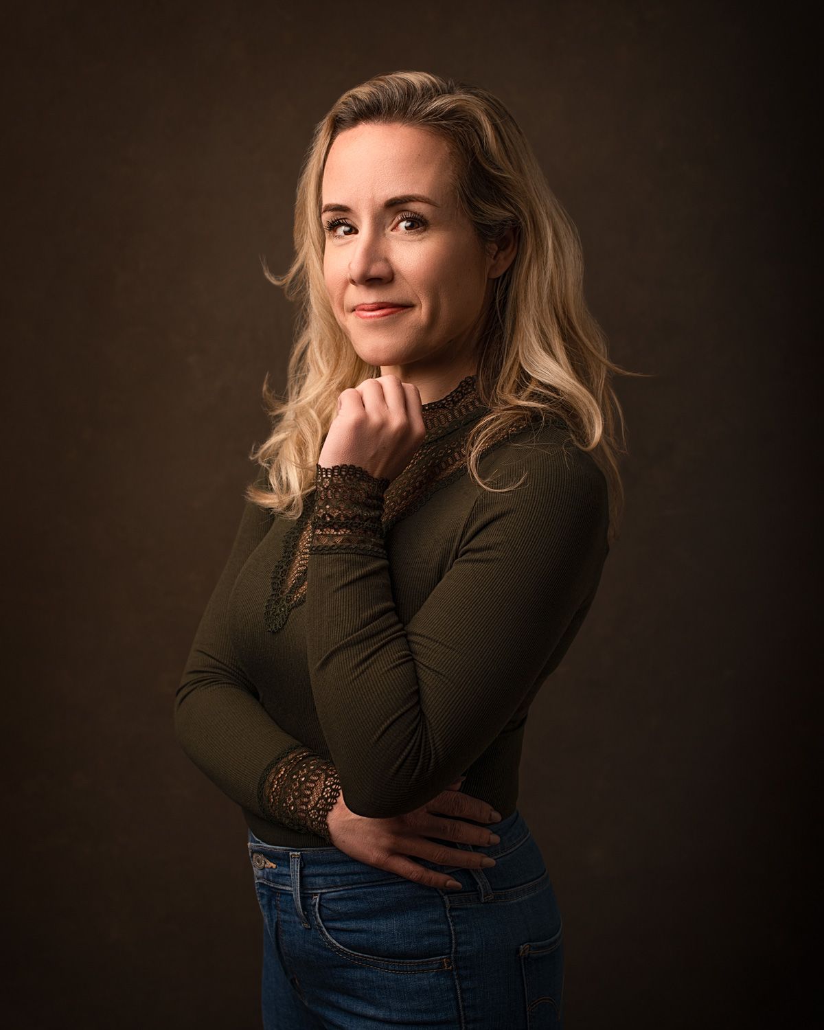 Portret van een vrouw van 40+, vastgelegd in diepe kleuren die haar authentieke schoonheid en kracht weerspiegelen.
