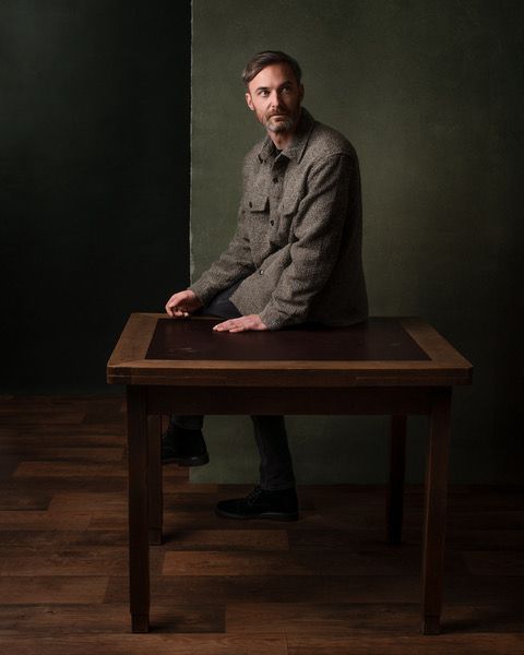 Stijlvol portret van een man in een creatieve setting, perfect voor artiesten en muzikanten die hun unieke uitstraling willen vastleggen.
