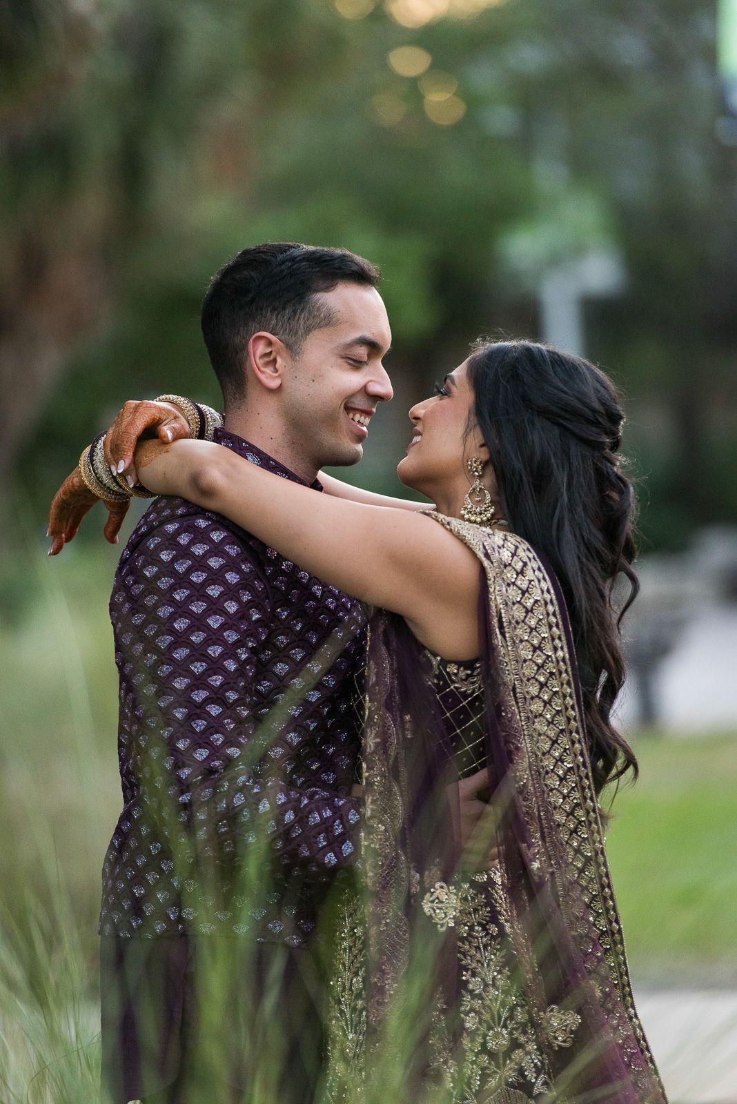 Couple in traditional Indian attire embracing outdoors.