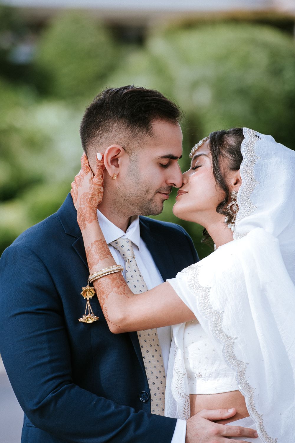 Close-up wedding portrait showing a tender embrace outdoors.