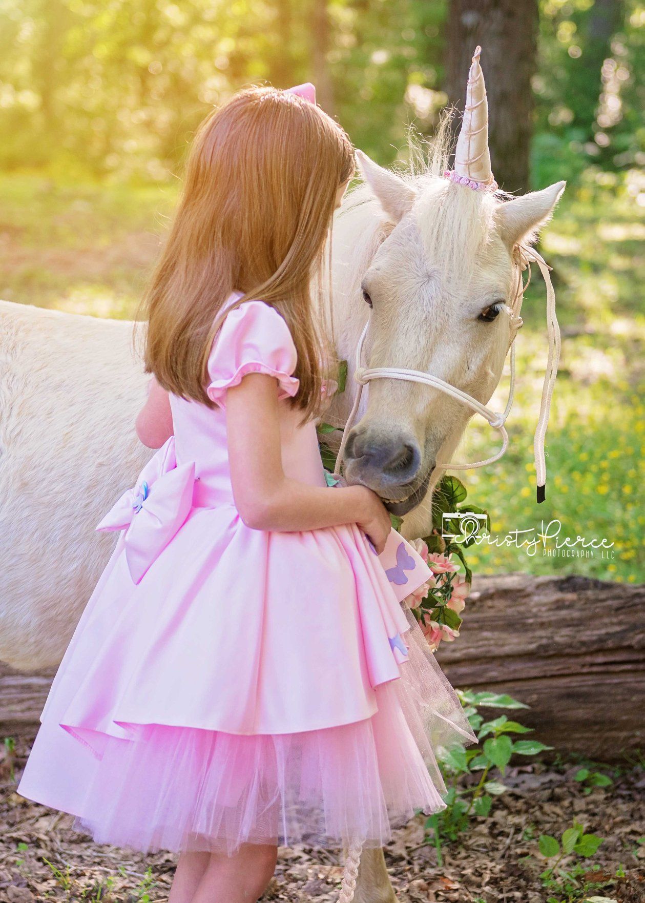 A magical scene with a pink-dressed figure gently bonding with a majestic white horse in a sunlit forest setting.