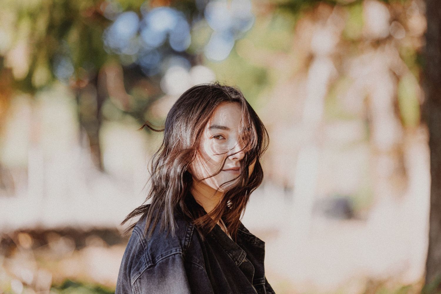 Portrait of a person with windswept hair in natural outdoor lighting.