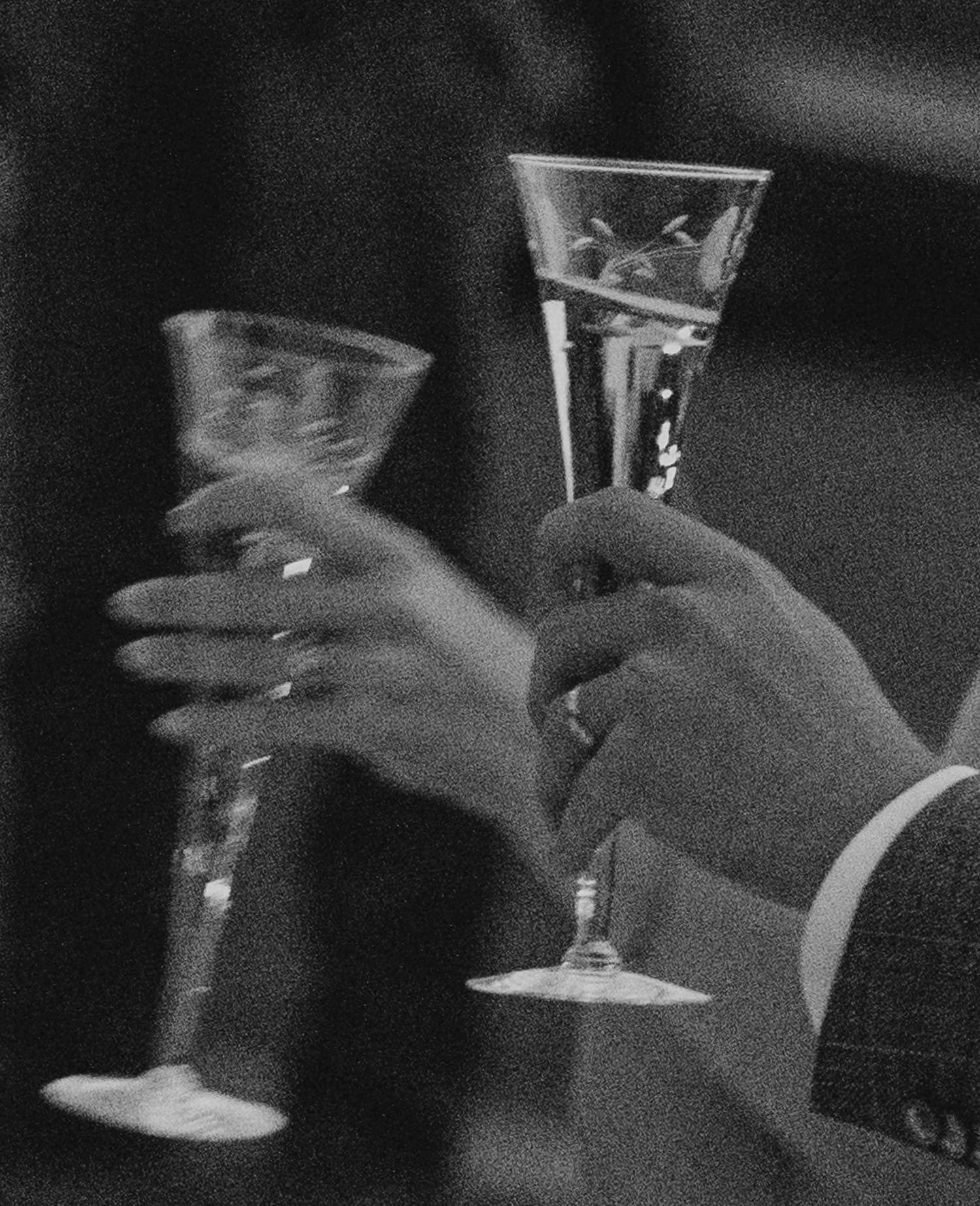 Two hands holding elegant champagne flutes in black and white for a celebratory toast.