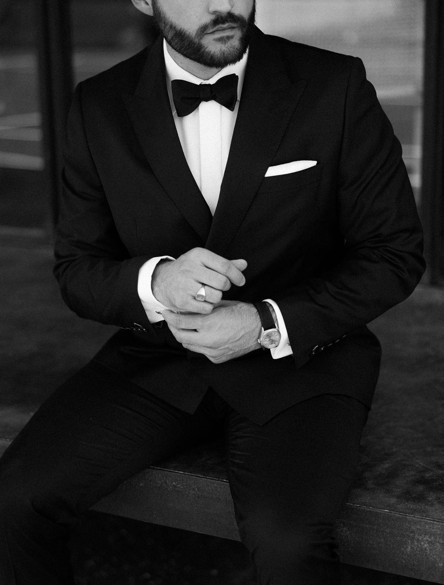 Close-up of a formal black tuxedo with bowtie and white pocket square.