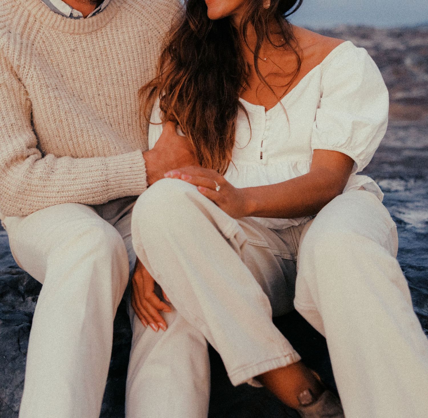 Intimate casual portrait of couple in neutral clothing sitting together.