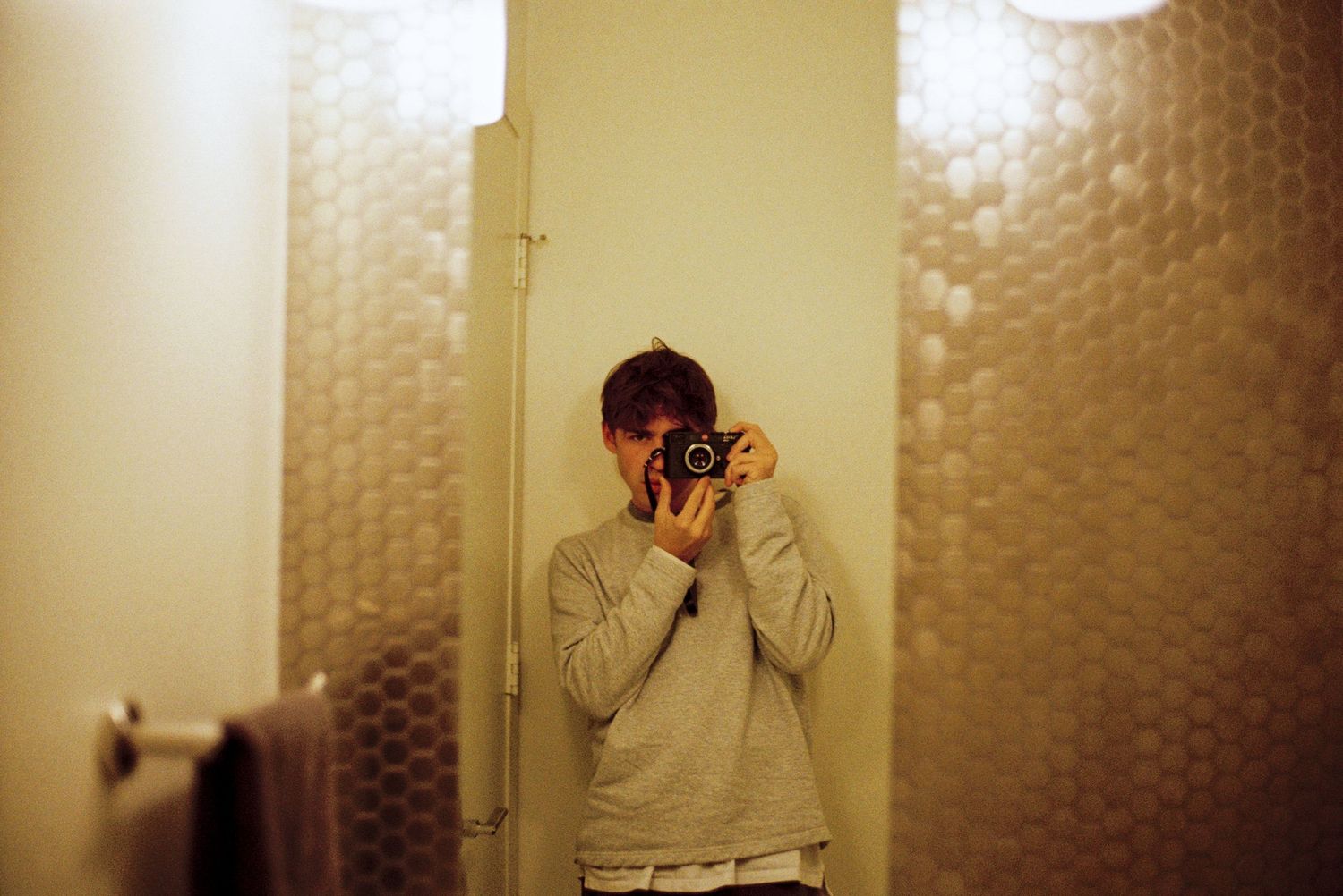A mirror selfie of someone taking a photo with a camera.