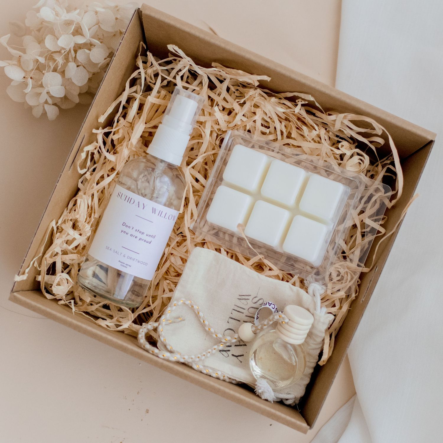 Gift box containing Sunday Willow products nestled in natural straw packaging.
