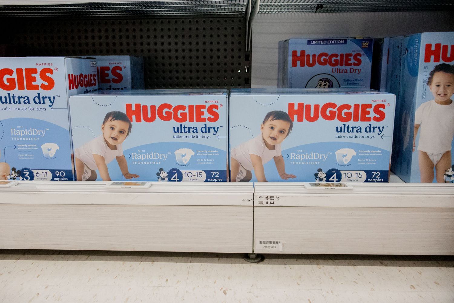 Boxes of Huggies Ultra Dry diapers lined up on retail store shelves showing packaging with product branding.
