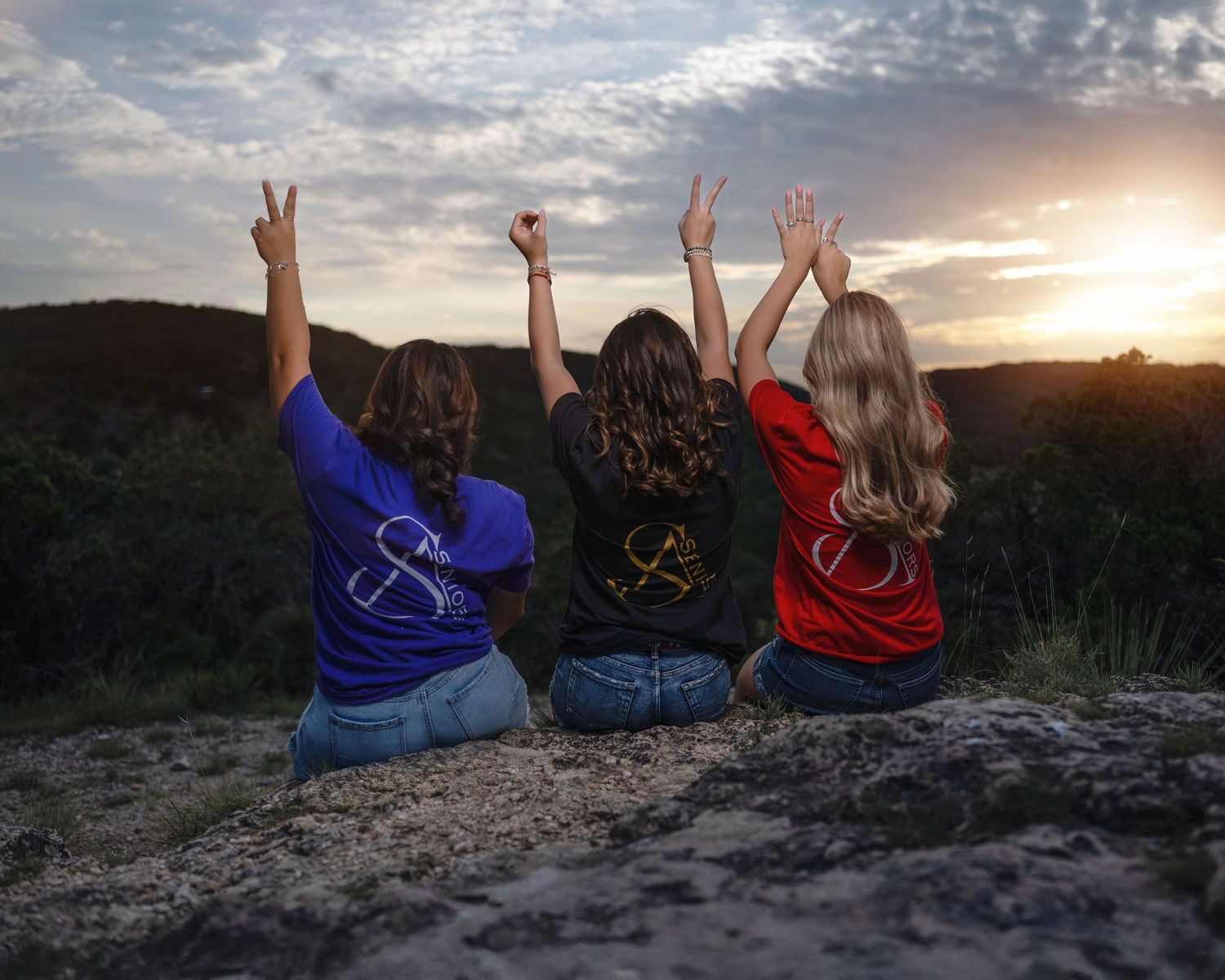A sequence of sunset photos showing three people sitting on a rocky ledge with raised hands celebrating at dusk.