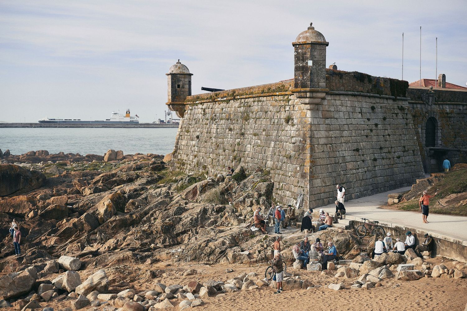 Ancient stone fortress with watchtowers overlooking a rocky coastline.