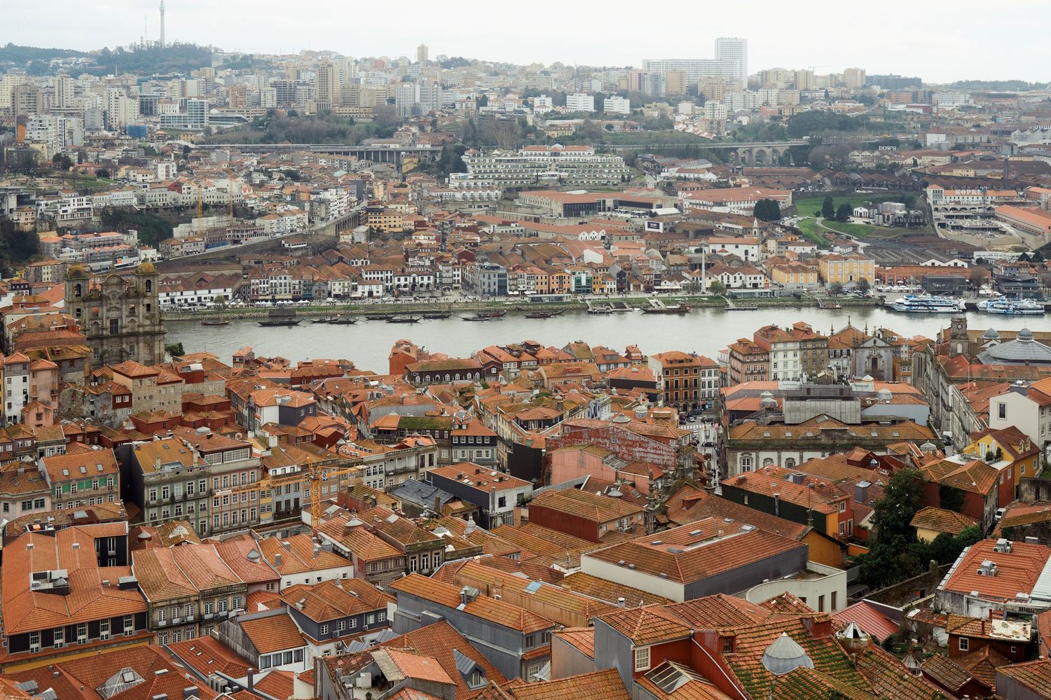 Aerial view of Porto's historic city center showing dense terracotta rooftops and urban landscape.