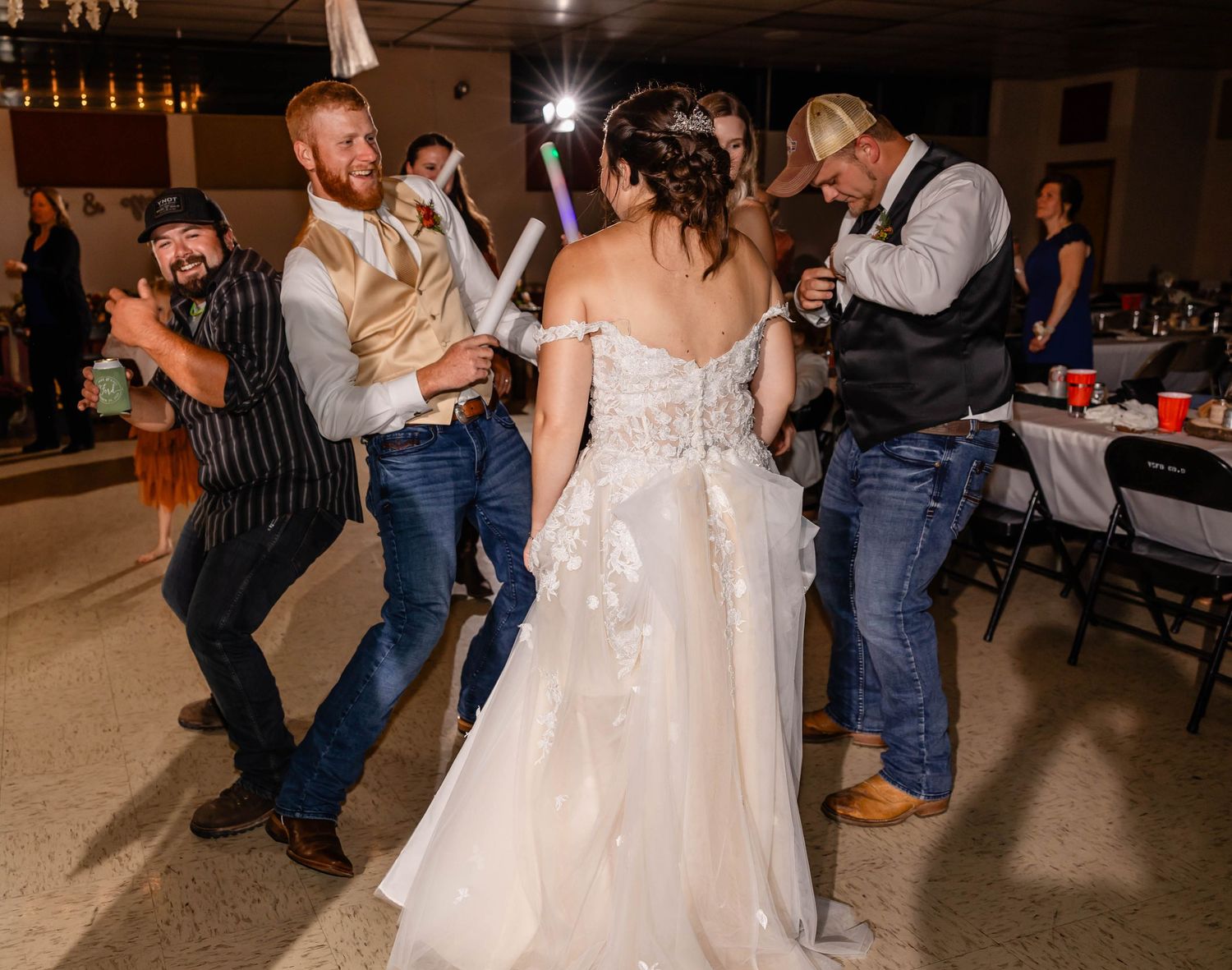 Energetic dance party moment captured during wedding reception with guests joining in.
