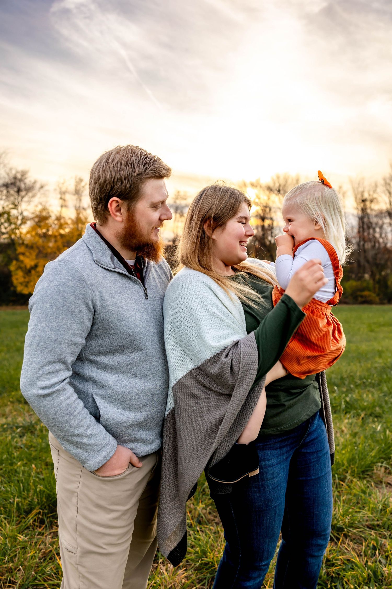 Intimate family portrait outdoors with warm sunset lighting.