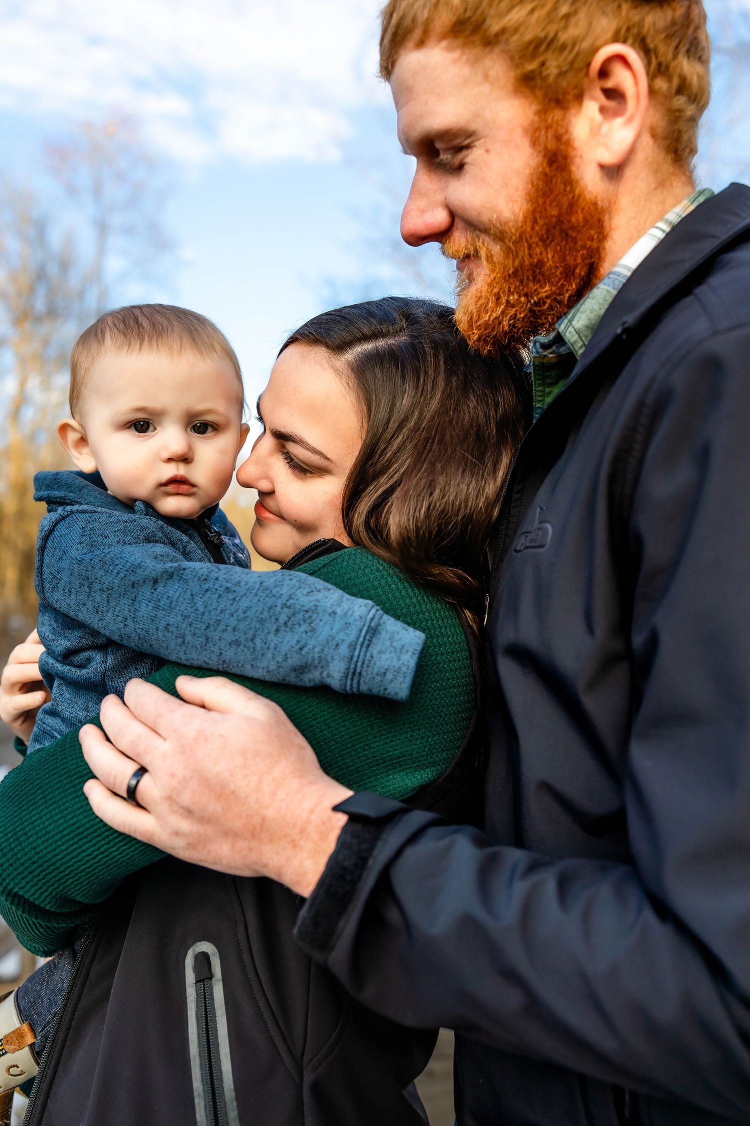 Close-up portrait of a loving family embracing on a snowy winter day.