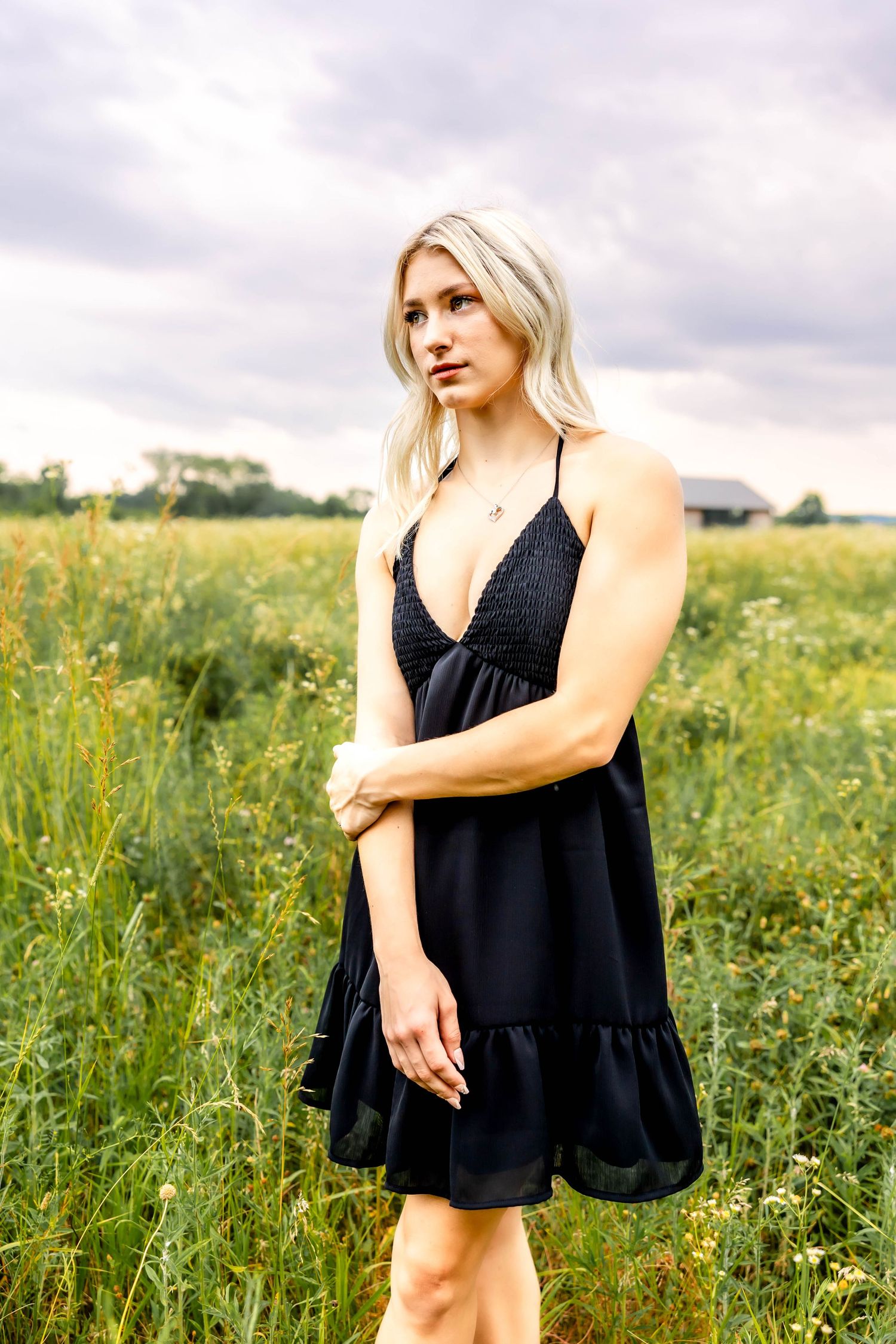 Elegant black sundress styled against a natural wildflower field backdrop.