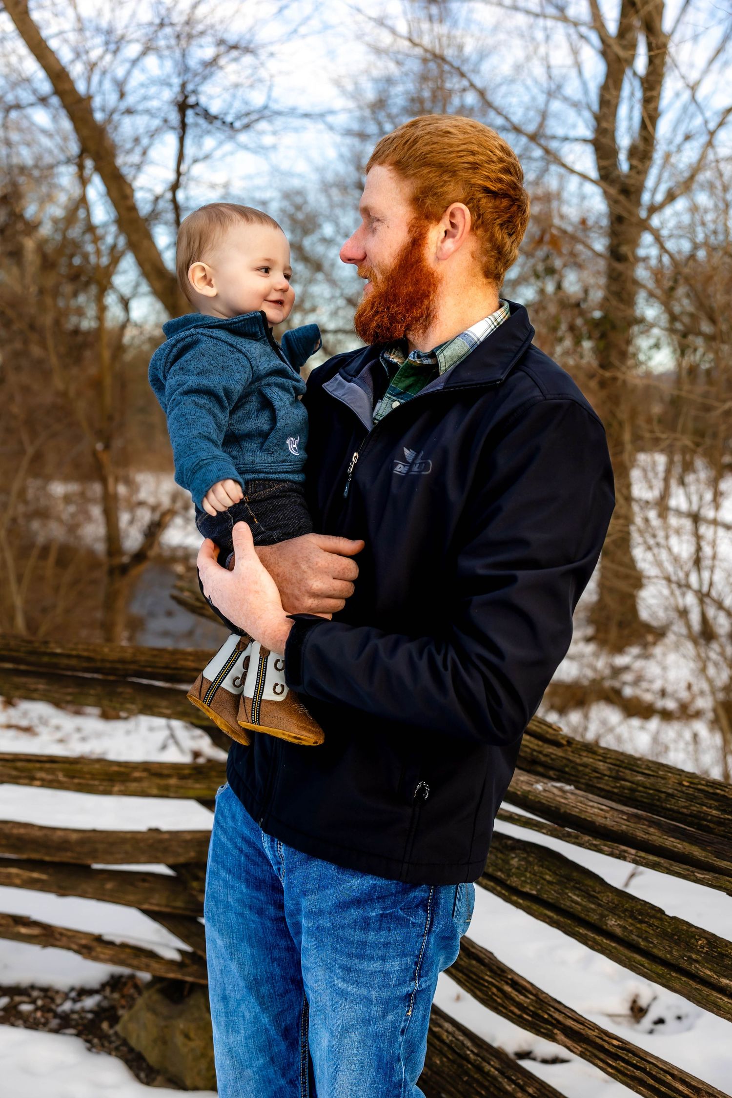 Playful interaction between father and young child on snowy winter day.