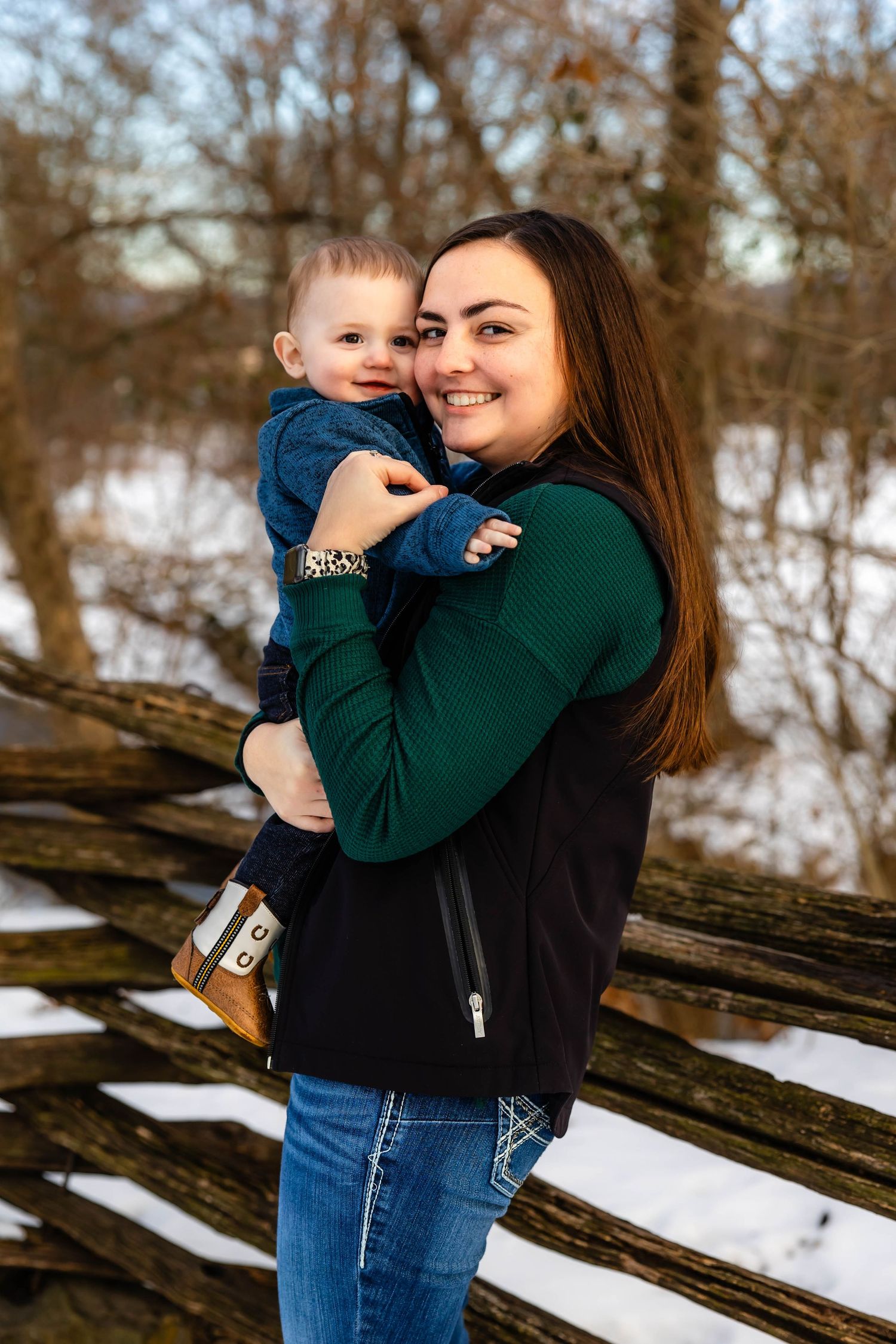 Mother and child share loving moment during winter photo session outdoors.